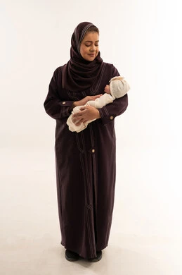 أم سعودية تحمل طفلها حديث الولادة في الاستوديو