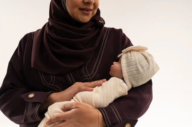 Arab Woman Holding Swaddled Newborn Baby in Studio