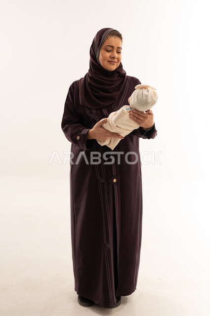 Arab Mother Holding Newborn Baby in White Studio Background