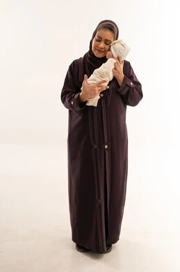 امرأة سعودية تحمل طفلاً حديث الولادة في الاستوديو