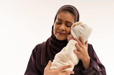أم إماراتية تحتضن طفلها حديث الولادة في الاستوديو