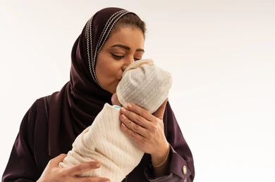 Arab Mother Kissing Newborn Baby in Studio Shot