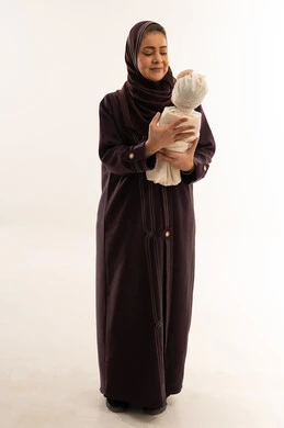 أم سعودية تحمل طفل رضيع في الاستوديو