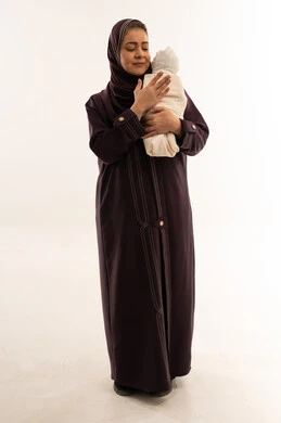 Saudi Mother Holding Swaddled Baby on White Background