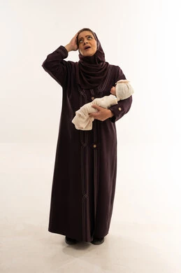 أم سعودية مرهقة تحمل طفلاً رضيعاً في الاستوديو