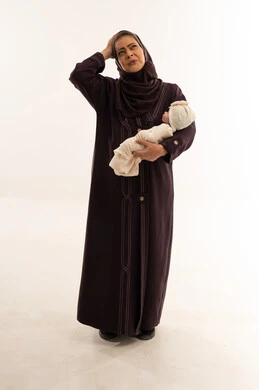 جدة سعودية تحمل طفل حديث الولادة في الاستوديو