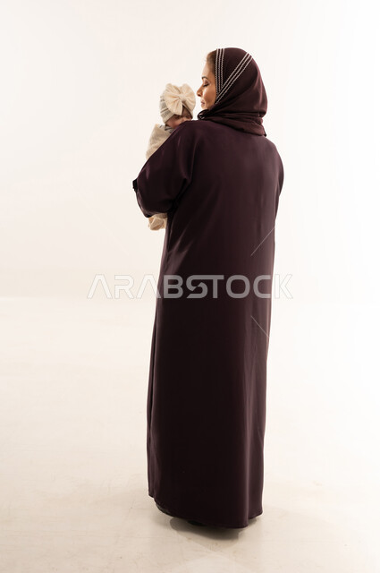 Saudi Mother in Abaya Holding Infant in Studio