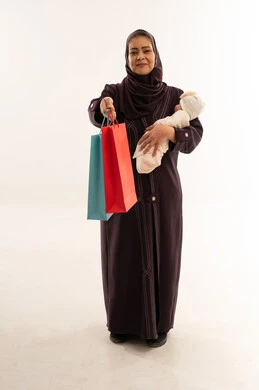 جدة سعودية تحمل مولوداً جديداً وحقائب تسوق