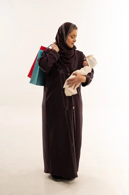 أم عربية مع رضيع وحقائب تسوق في الاستوديو