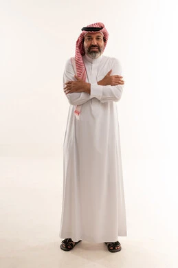 رجل سعودي بالثوب التقليدي أمام خلفية بيضاء