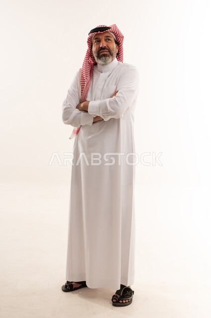 رجل سعودي بالزي التقليدي في استوديو بخلفية بيضاء