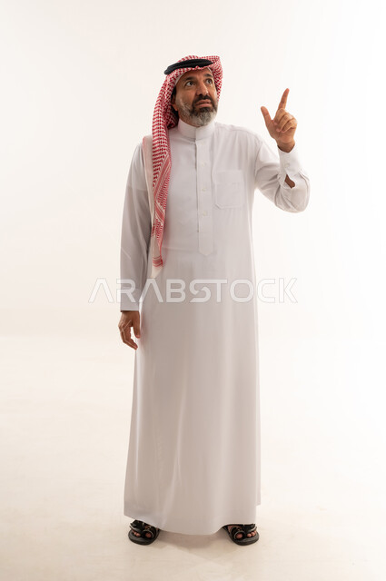 رجل سعودي يشير للأعلى على خلفية بيضاء