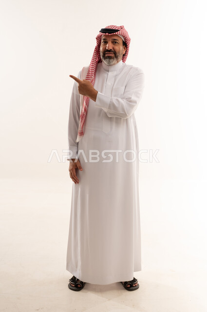رجل سعودي بالزي التقليدي يشير على خلفية بيضاء
