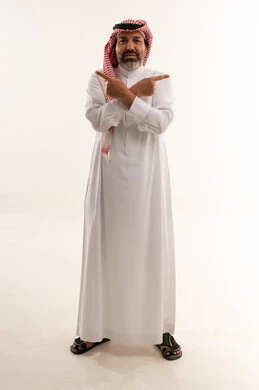 رجل سعودي يشير لاتجاهين مختلفين بخلفية بيضاء