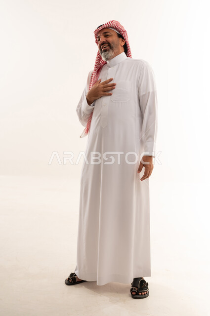 رجل سعودي بالثوب التقليدي يضع يده على صدره