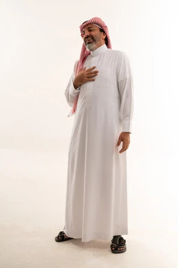 رجل سعودي بالثوب التقليدي يضع يده على صدره