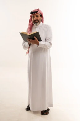 رجل سعودي يمسك كتاباً بخلفية بيضاء