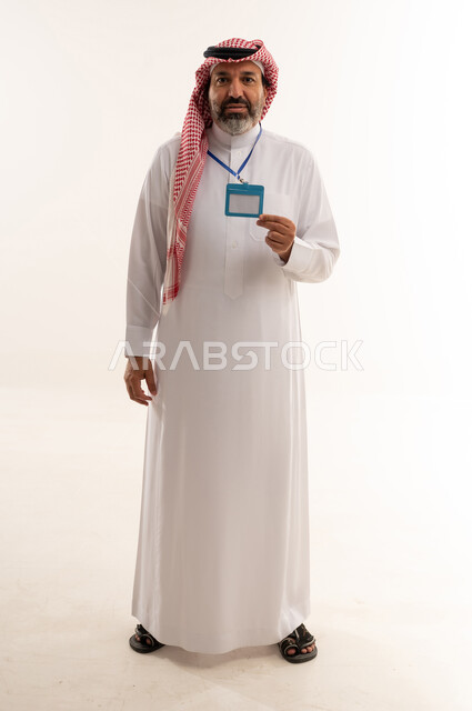 رجل سعودي بالزي التقليدي يحمل بطاقة هوية