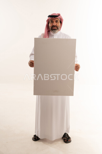 Saudi Man in Traditional Thobe Holding Blank White Board