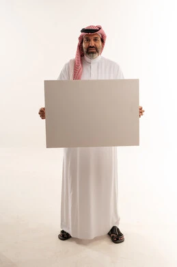 رجل سعودي بالزي التقليدي يحمل لوحة فارغة