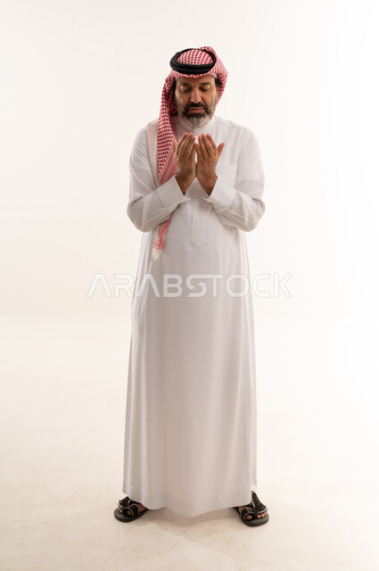 Saudi Man in Traditional Attire Praying on White Background