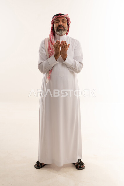 Saudi Man in Traditional Thobe Praying White Background