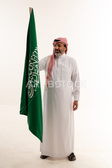 Saudi Man Holding National Flag in White Studio
