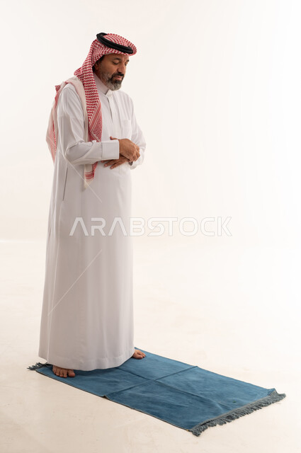 Saudi Man Praying on Blue Mat White Background