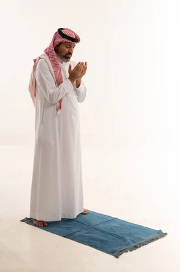 رجل سعودي يصلي ويدعو في استوديو بخلفية بيضاء