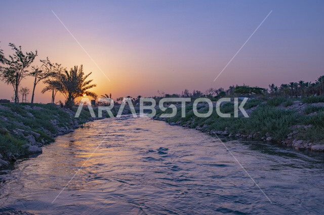 صورة جمالية للأشجار محيطة ببحيرة أثناء غروب الشمس، أماكن طبيعية سياحية، غروب الشمس، احجار صخرية، اطلالة ساحرة للطبيعة الخلابة
