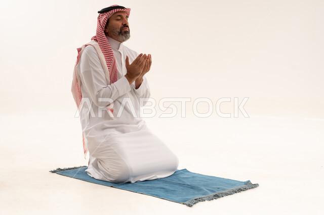 Saudi Man Praying on Mat in White Studio