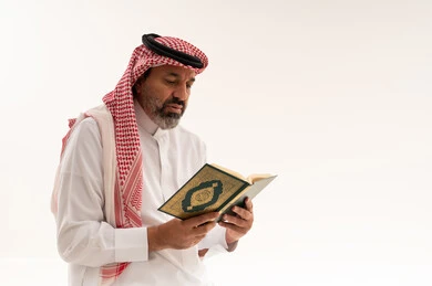 Saudi Man Reading Holy Quran on White Background