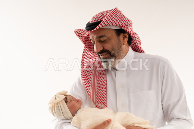 Saudi Man Holding Sleeping Newborn Baby in Studio