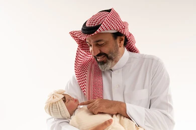 Saudi Man Holding Newborn Baby in Traditional Attire