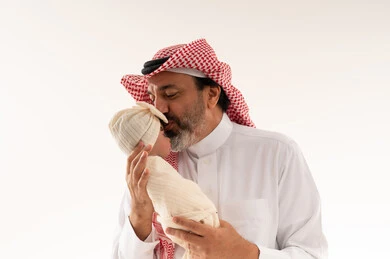 أب سعودي يقبل طفله حديث الولادة في الاستوديو