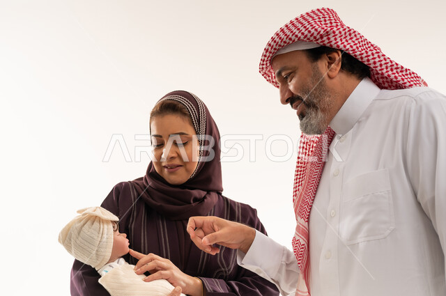 عائلة سعودية مع مولود جديد بملابس تقليدية في الاستوديو