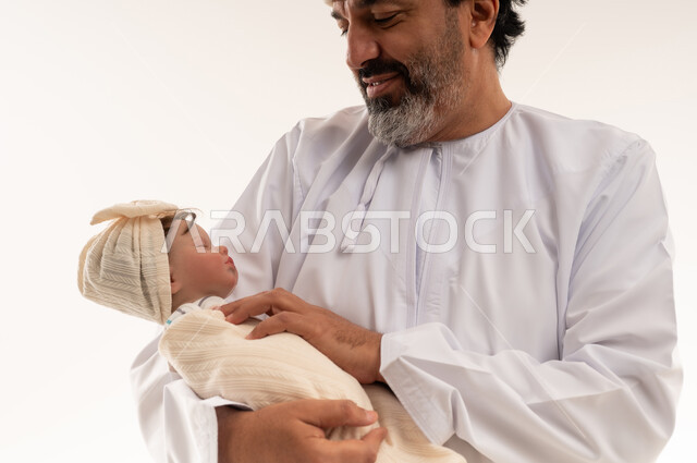 رجل عربي يحمل مولوداً جديداً في الاستوديو