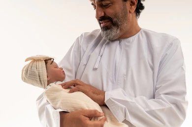 رجل عربي يحمل مولوداً جديداً في الاستوديو