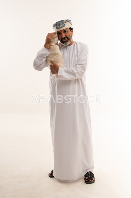 Omani Man in Traditional Dress Holding Newborn Baby