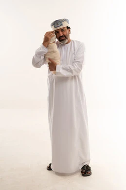 Omani Man in Traditional Dress Holding Newborn Baby