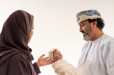 عائلة عمانية مع طفل حديث الولادة في الاستوديو