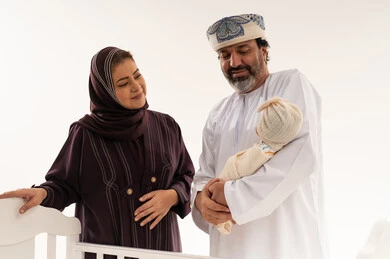 عائلة عُمانية مع طفل حديث الولادة في استوديو