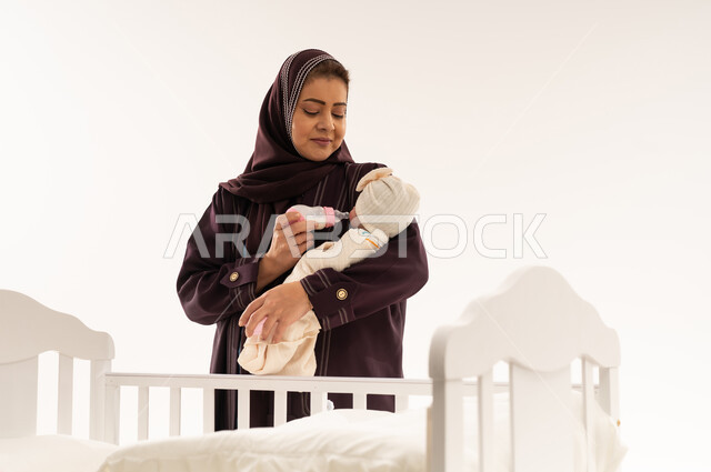 Saudi Mother Feeding Newborn Baby with Bottle