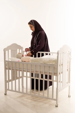 Saudi Mother with Newborn Baby in White Crib