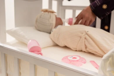 إرضاع طفل حديث الولادة في سرير خشبي