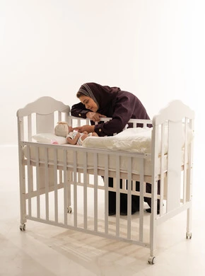Saudi Mother with Newborn in White Crib Studio