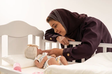 Saudi Woman Caring for Newborn Baby in White Crib