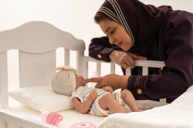 Saudi Woman with Baby Doll in White Nursery Crib Saudi Woman with Baby Doll in White Nursery Crib