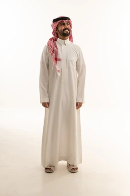 رجل سعودي بالزي التقليدي أمام خلفية بيضاء