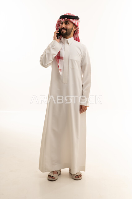 Saudi Man in Thobe Talking on Smartphone Studio Shot